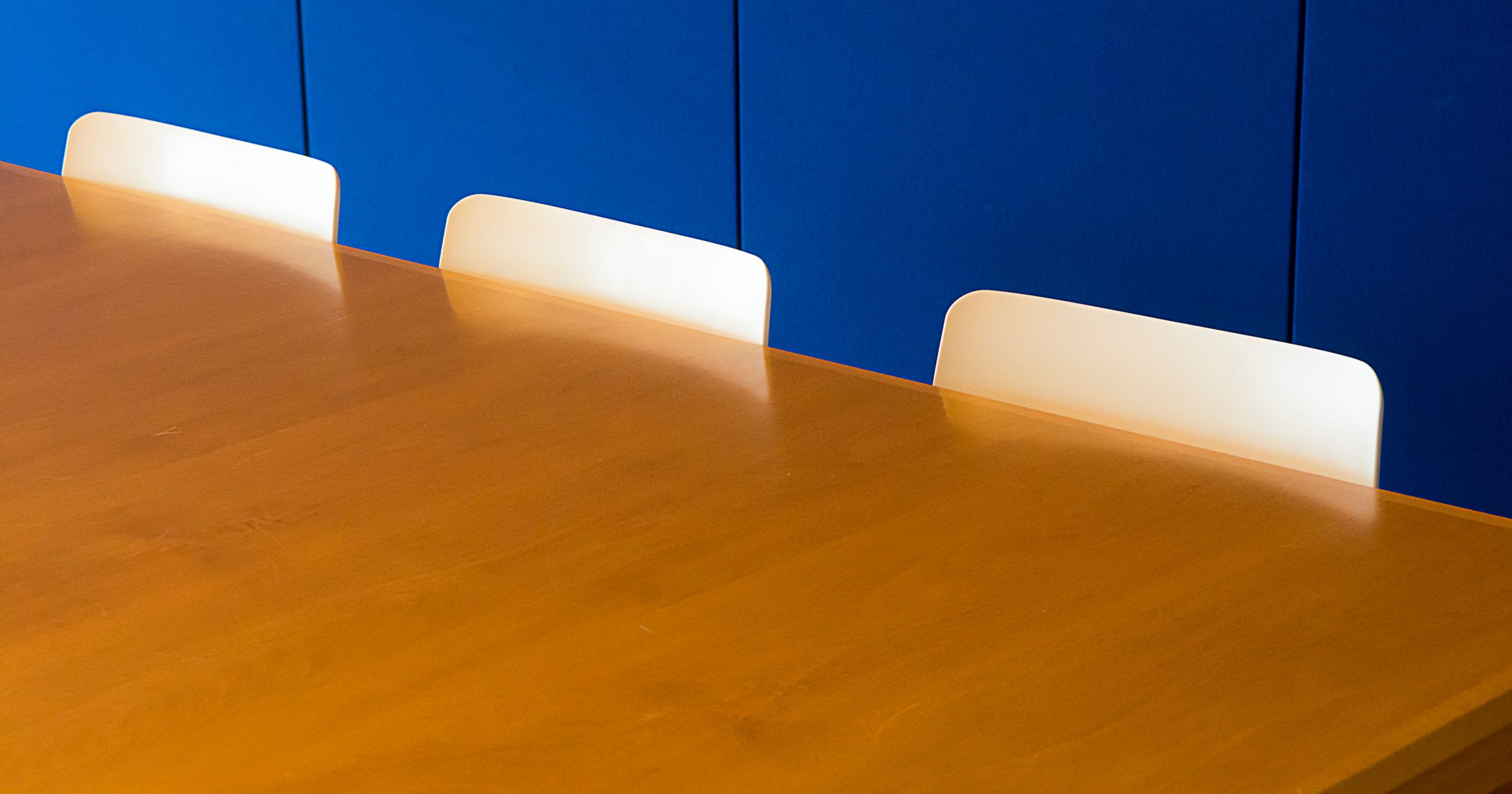A conference table in a creative agency, with laptops, contracts, and studio owners meeting across it
