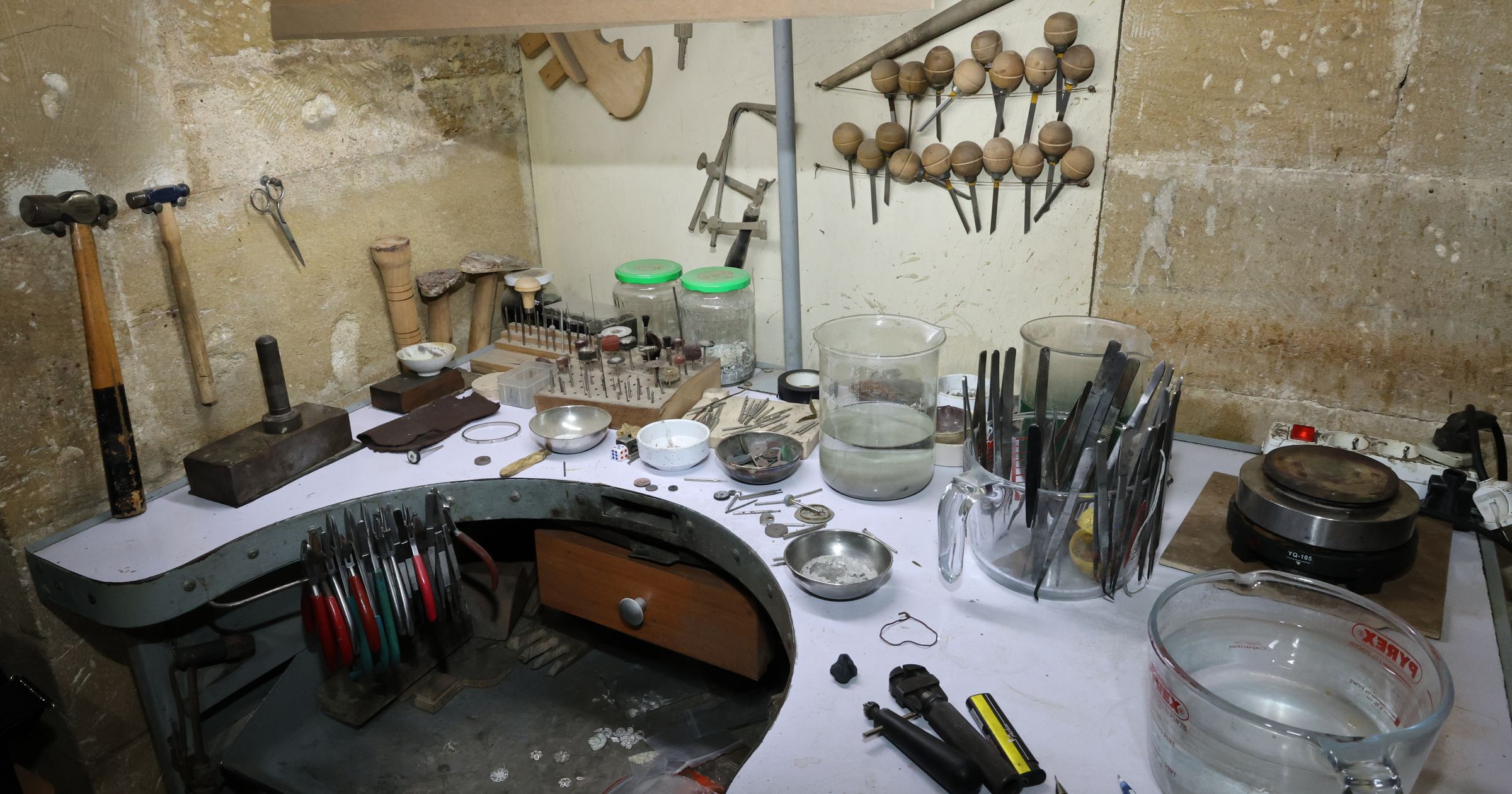 A clean, well-organized wooden workshop bench with precision tools arranged neatly.