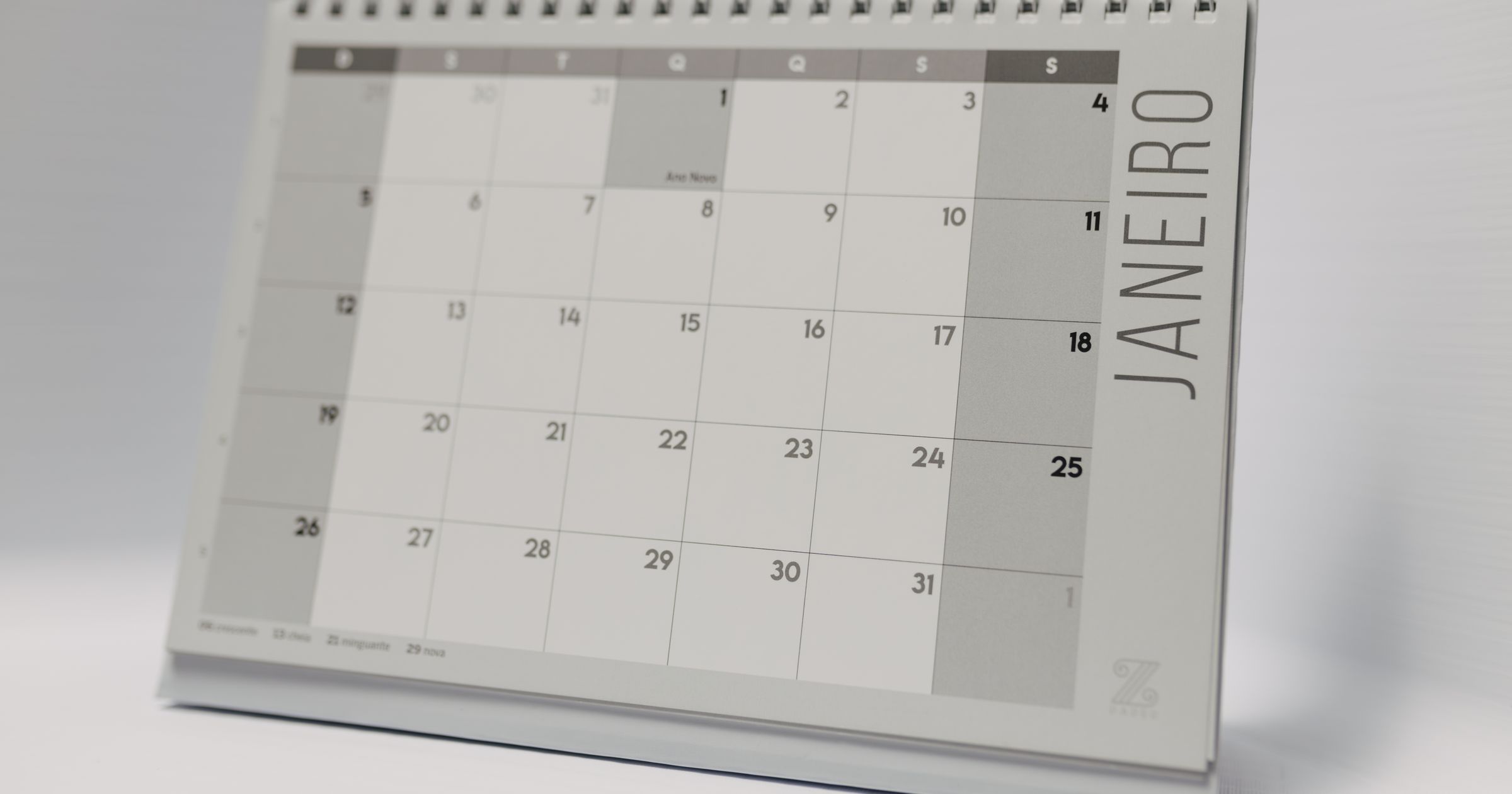 A desk with a calendar, a laptop, and a running timer beside notes and invoices.