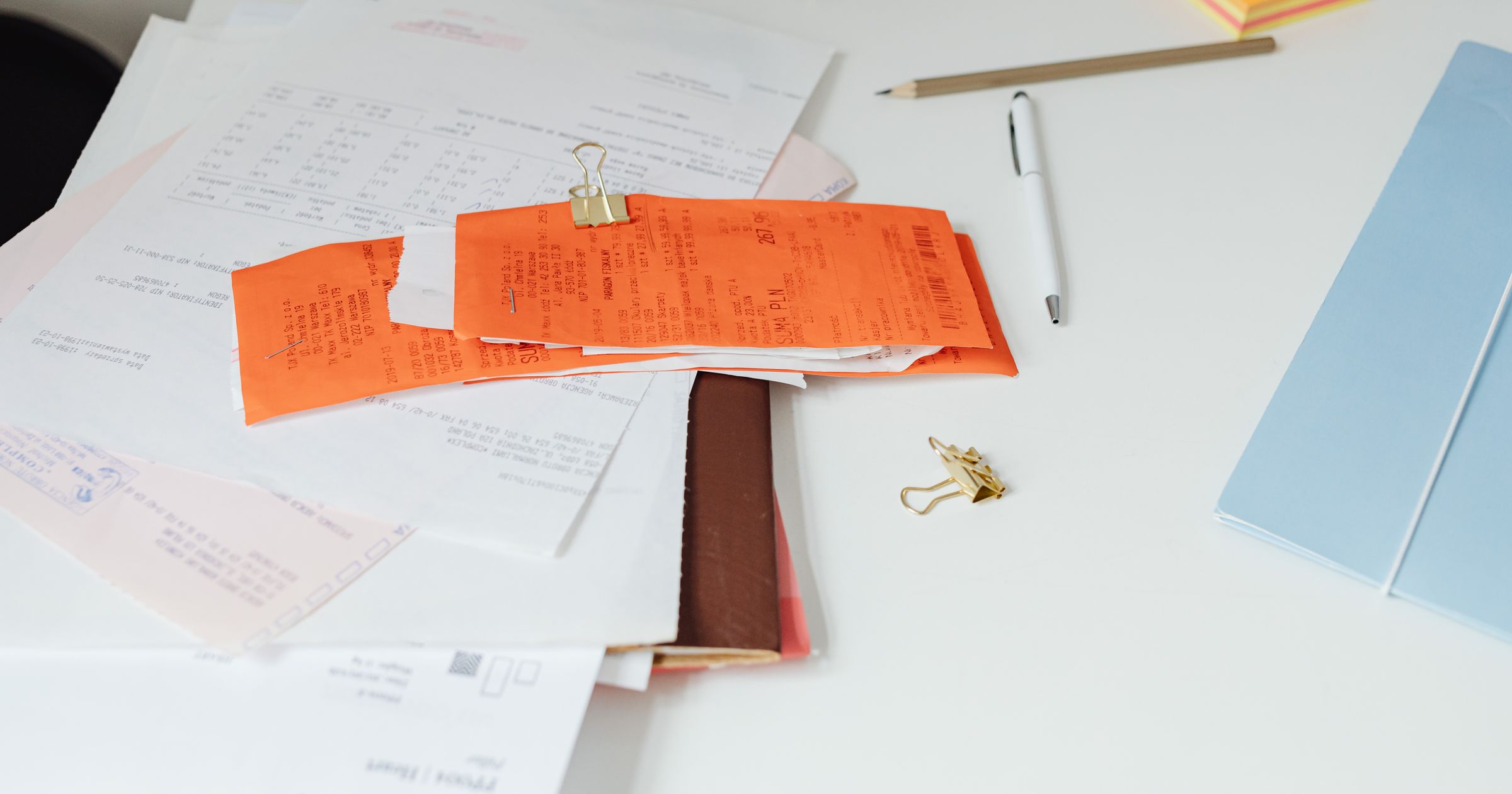 A clean studio desk with a paper ledger, pen, and digital tablet displaying billing data.