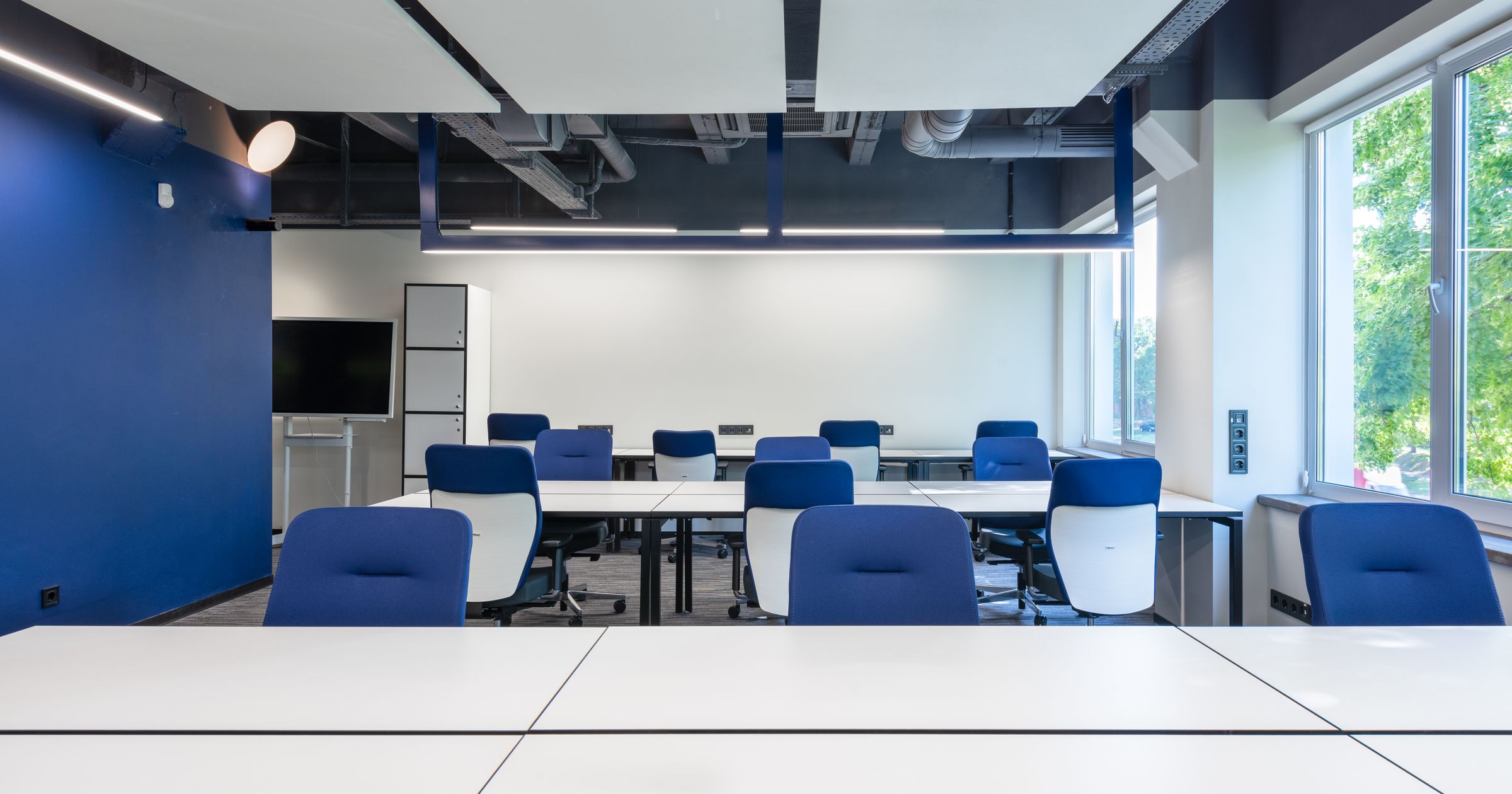 A row of desks in a small studio office, showing an expanding team workspace