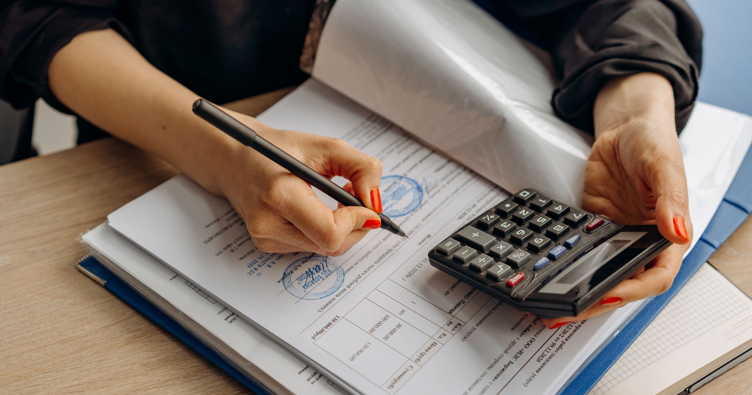 A ledger beside a laptop showing tracked work and invoice records
